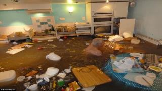 متقاعد يقدم على السباحة في مطبخه بعد أن غمرت مياه الفيضانات منزله